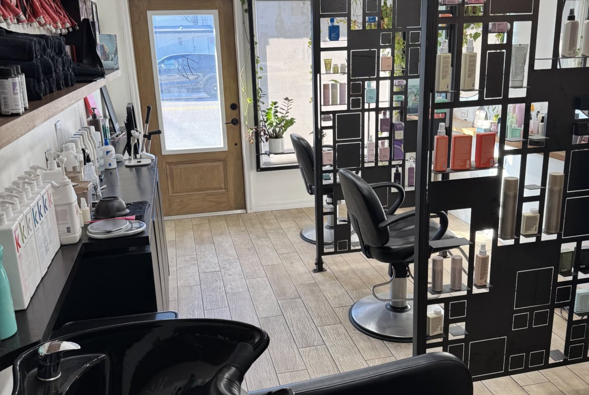 Modern hair salon interior with styling stations and product shelves, perfect for salon rental businesses.