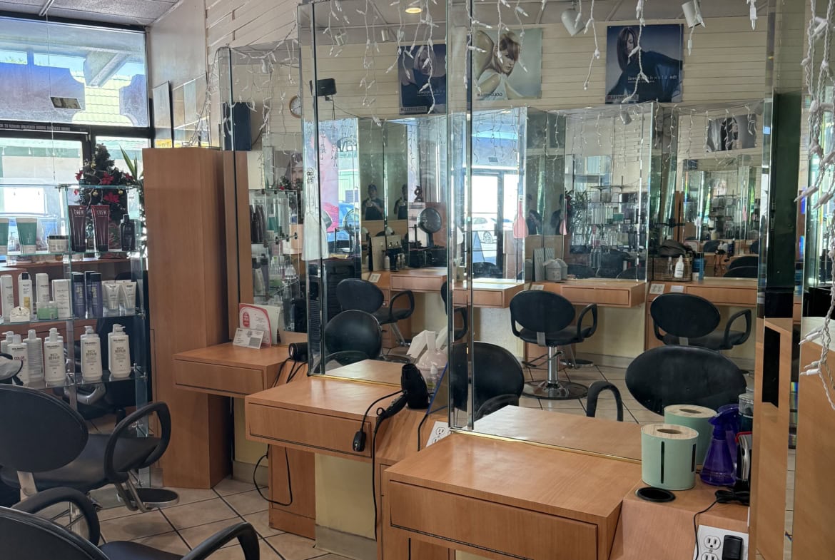 Clean hair salon styling stations with mirrors, chairs, and salon products for lease or rent.
