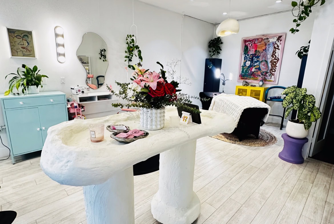 Bright, modern salon interior with vibrant decor, plants, and creative seating areas.