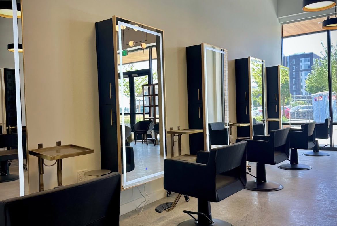 Elegant salon styling stations with mirrors, chairs, and modern decor, perfect for a professional hair salon.