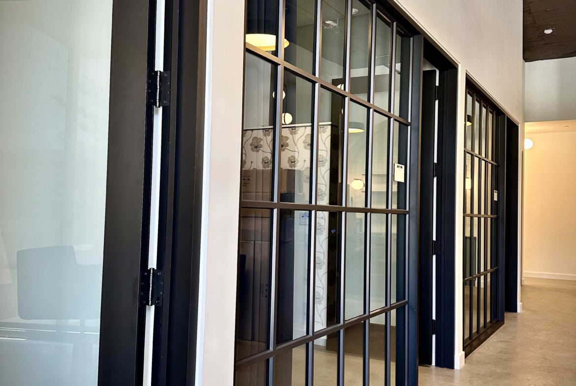Modern glass partition walls in a salon, creating stylish private spaces.