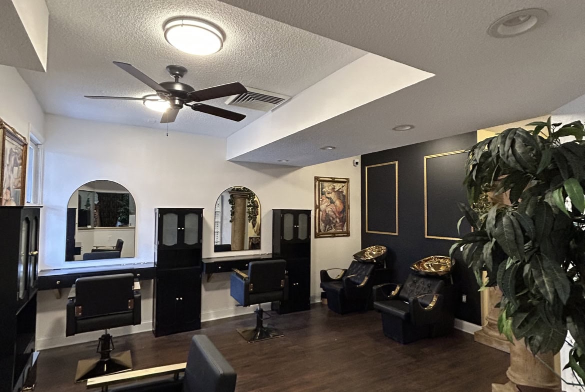 Stylish salon interior featuring modern styling stations, comfortable chairs, and elegant decor.