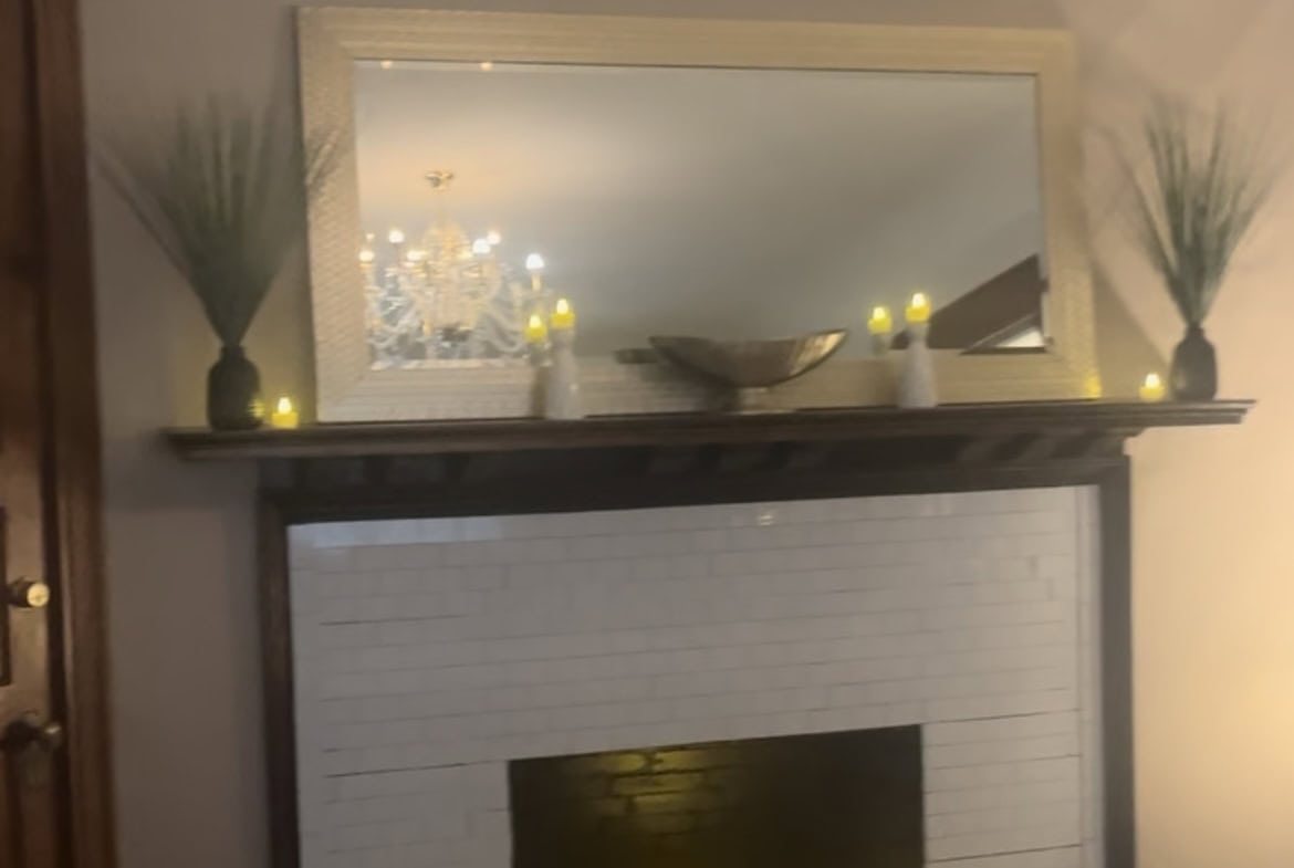 Elegant salon fireplace with candles, mirror, and decorative accents.