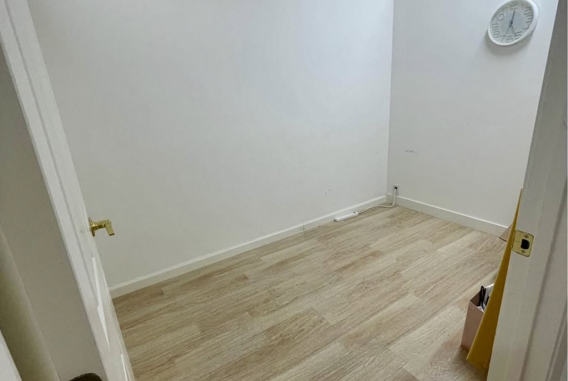 Empty salon rental room with white walls and wood flooring | Ideal for salon or beauty business.