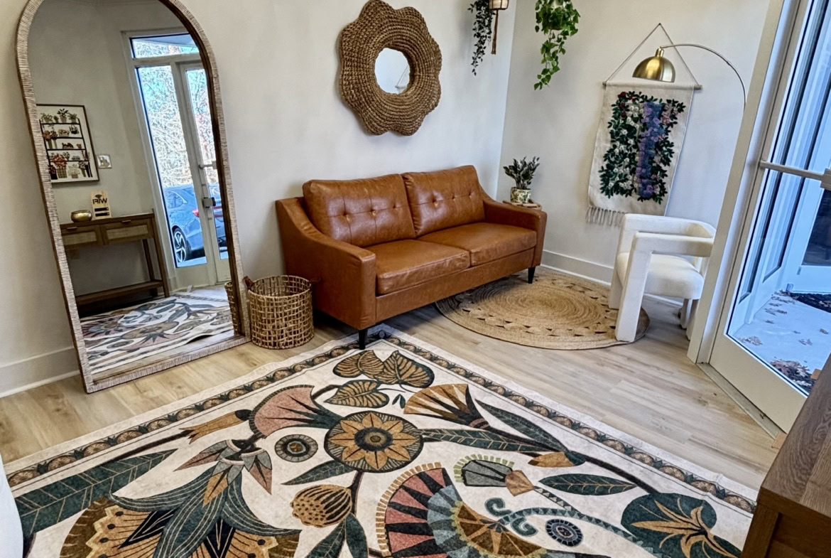 Bright cozy salon waiting area with natural light, modern decor, and vibrant rug for relaxation.