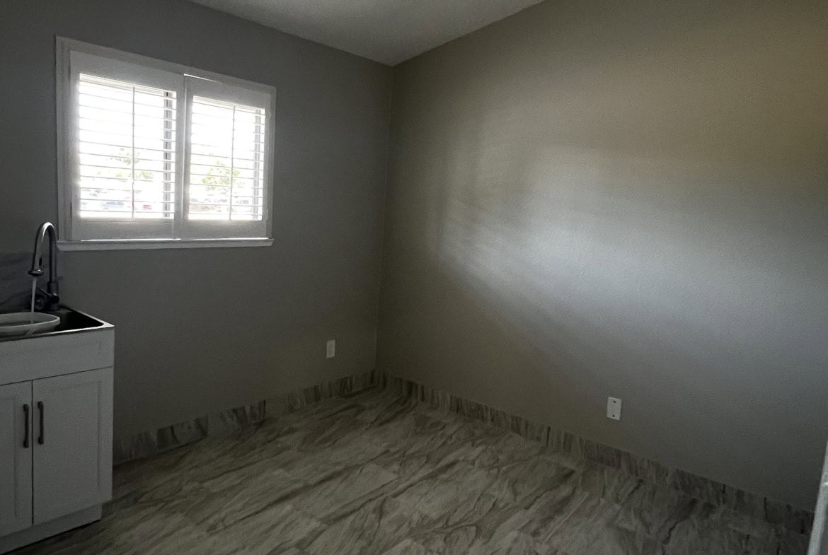 Bright salon room with window, neutral walls, and flooring suited for a professional beauty environment.
