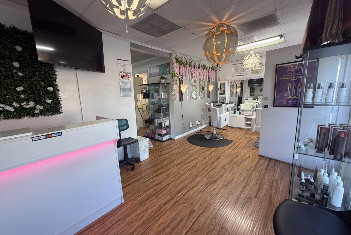 Bright salon interior with modern decor, styling chairs, and beauty product displays in a welcoming atmosphere.
