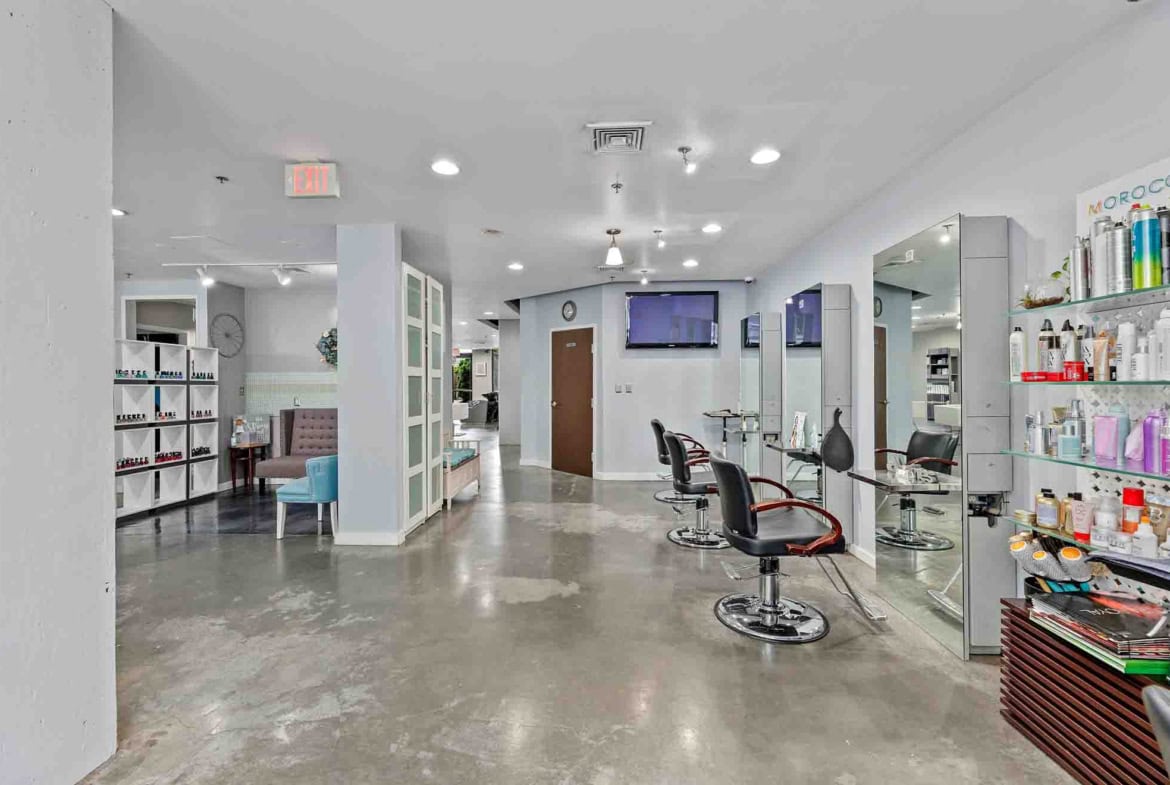 Bright salon with styling chairs, mirrors, and hair care products for professional hair styling.