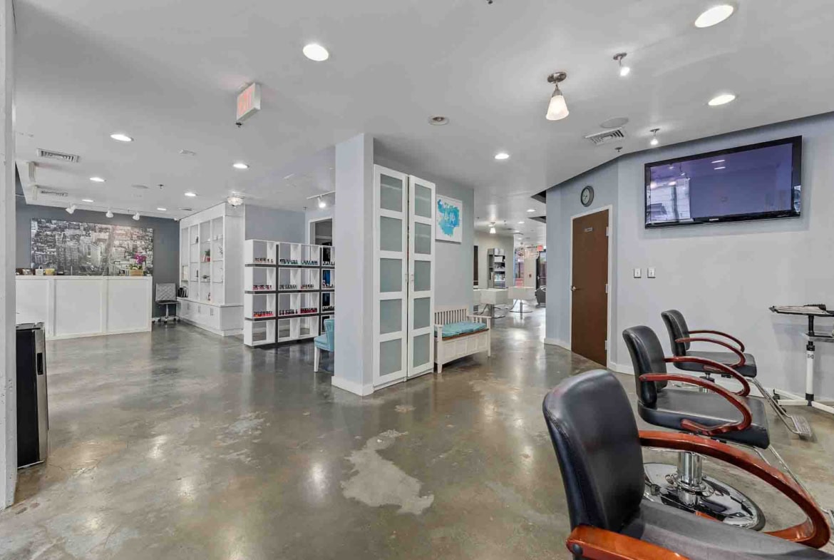 Spacious salon with styling chairs, nail stations, and contemporary decor for beauty services.