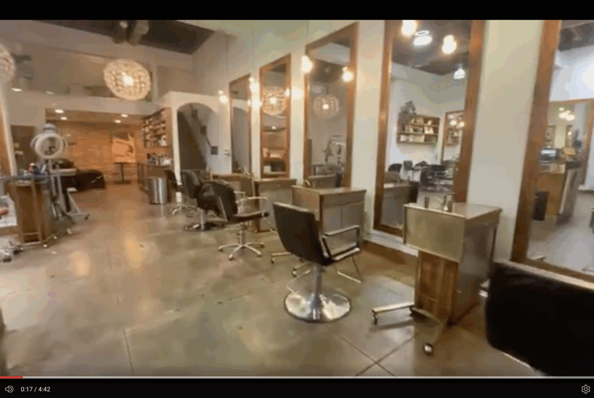 1. Modern salon station with hairdressing chairs and mirrors, stylish decor, and warm lighting.