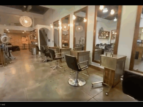 1. Modern salon station with hairdressing chairs and mirrors, stylish decor, and warm lighting.