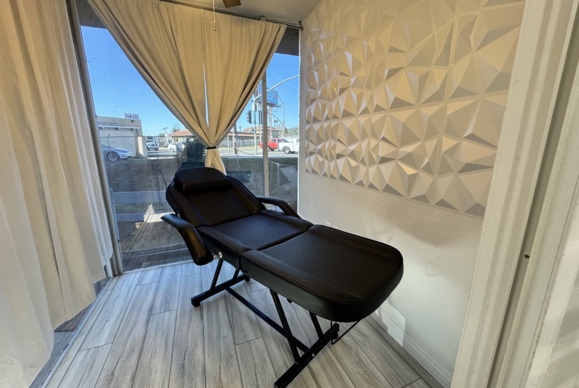 Professional massage or facial treatment room with relaxing ambiance and comfortable adjustable bed.