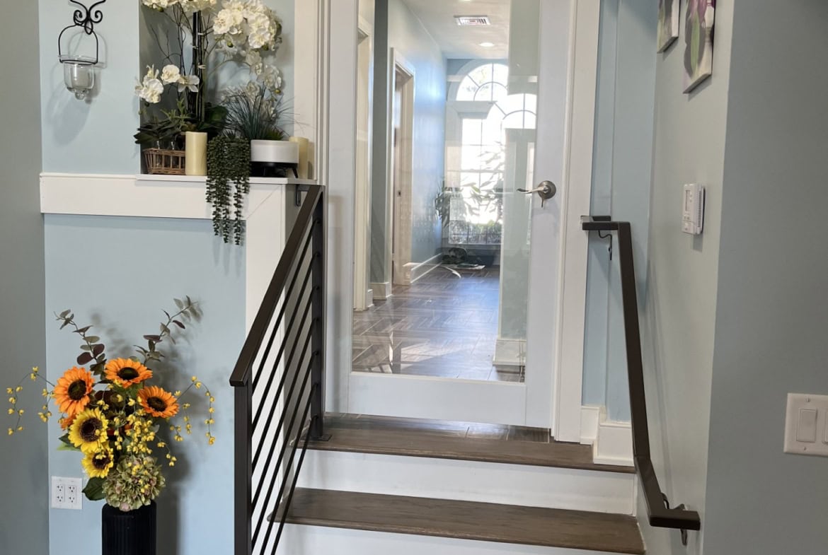 Bright, modern salon entryway with wooden stairs, elegant decor, and natural light.
