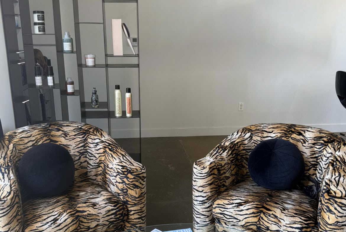 Elegant salon waiting area with tiger print armchairs and modern decor.
