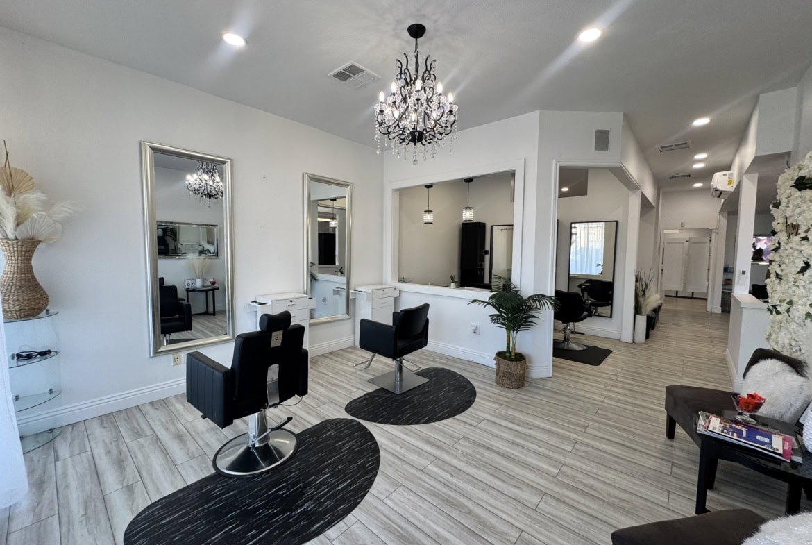 Modern salon interior with styling stations, mirrors, and elegant decor, perfect for beauty and hair services.