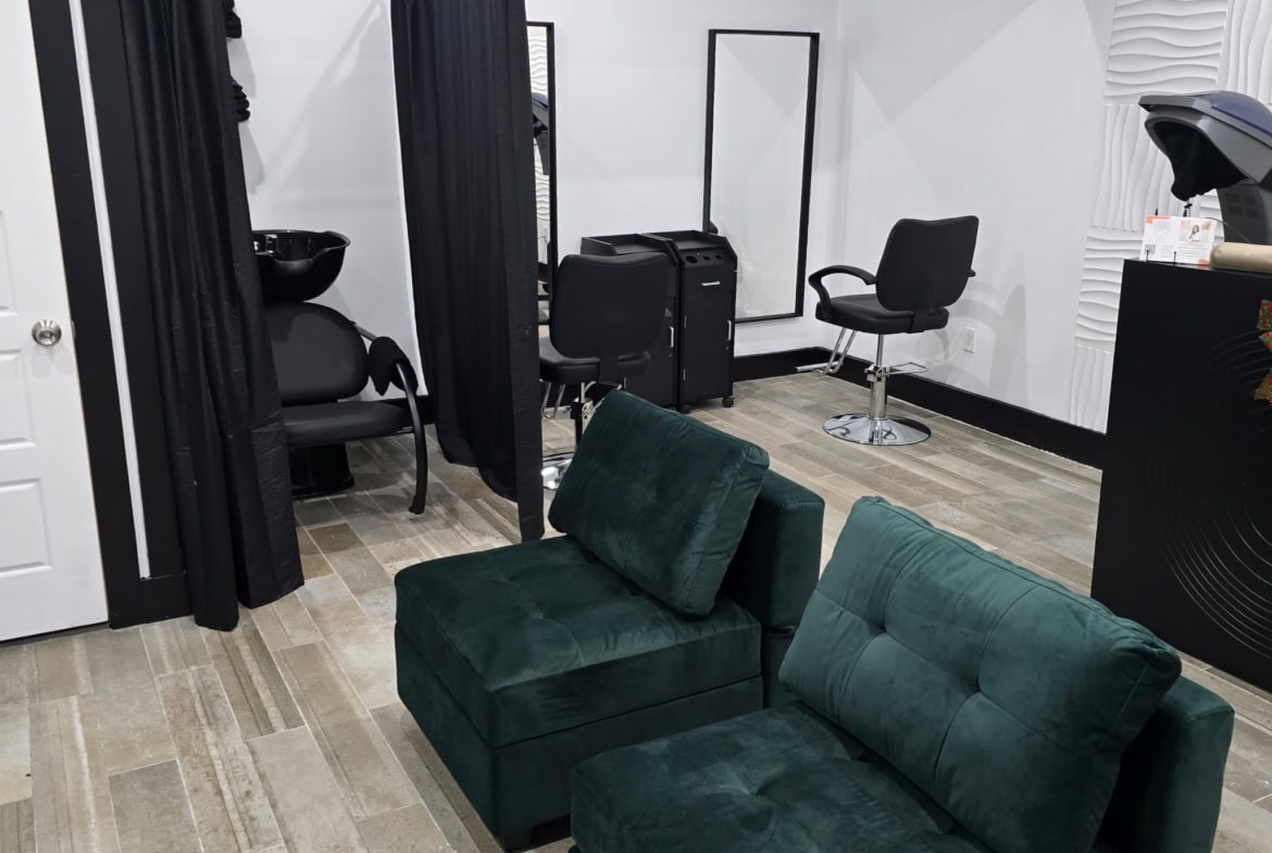 Relaxing salon waiting area with styling stations and black privacy curtains for hair services.