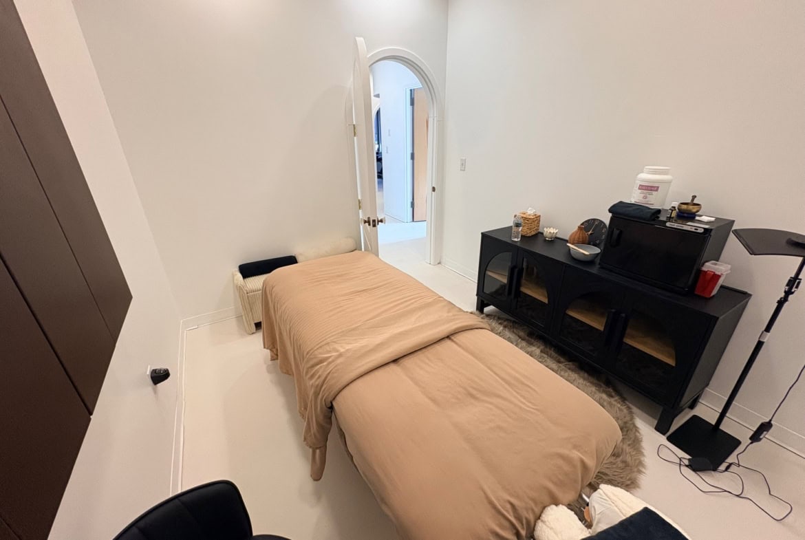 Relaxing massage room with cozy bed and professional equipment at Salon Renter.