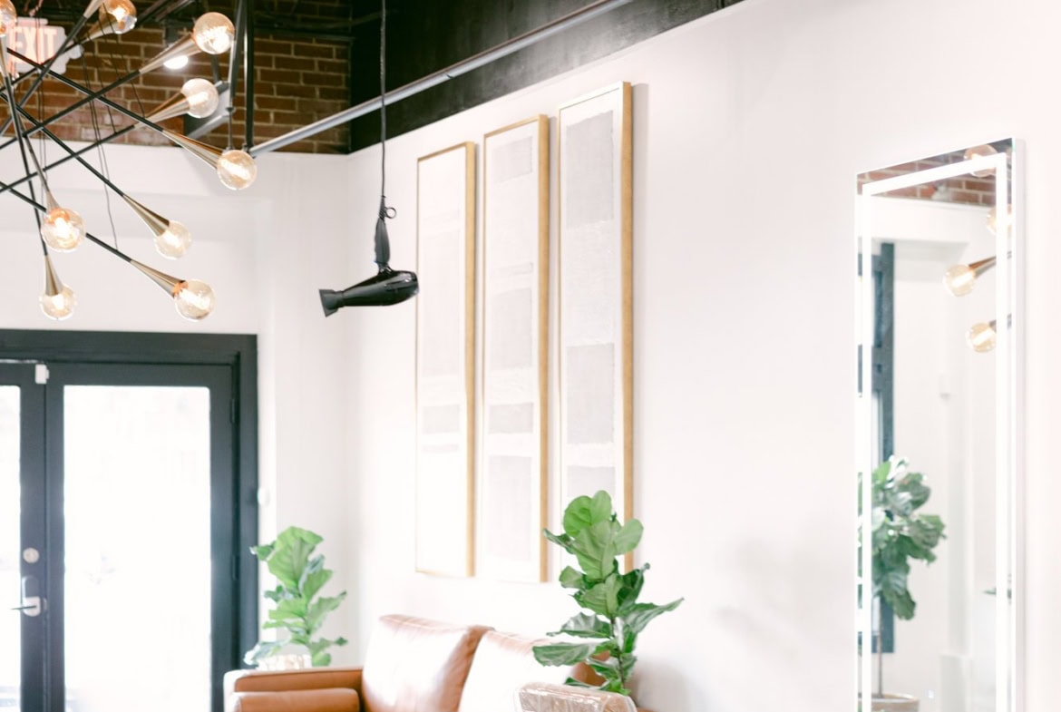 Contemporary salon space with comfortable seating, large mirrors, and modern decor.