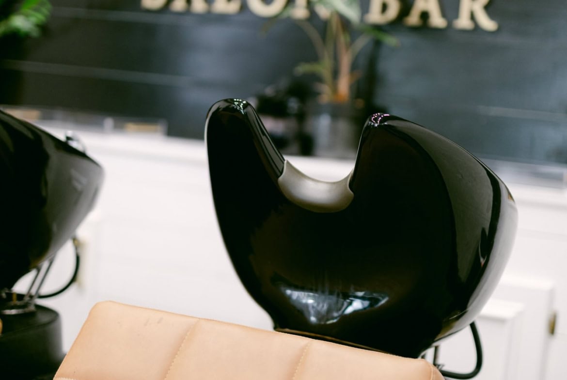 Stylish black salon chair and wash basin in a historic Roswell salon setting.