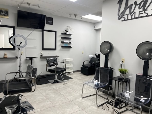 Stylish hair salon station with chairs, mirrors, and hair drying equipment for professional styling.
