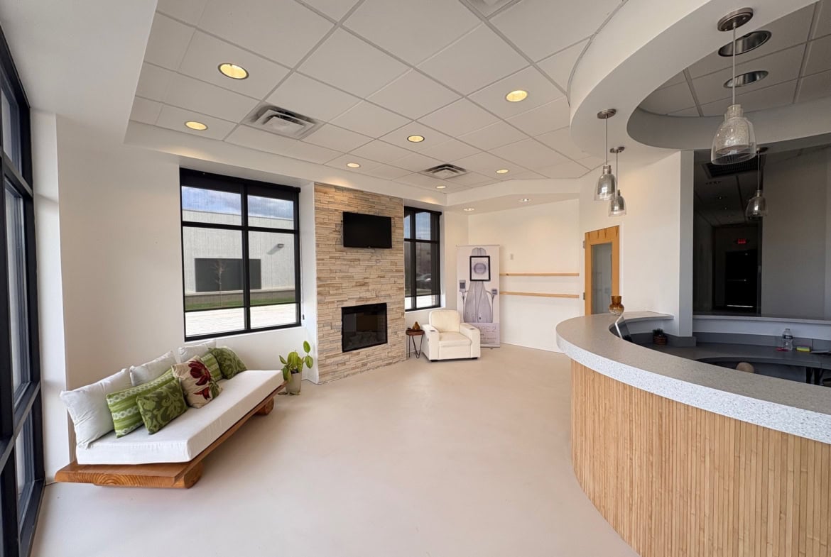 Modern salon reception with comfortable seating and large windows.