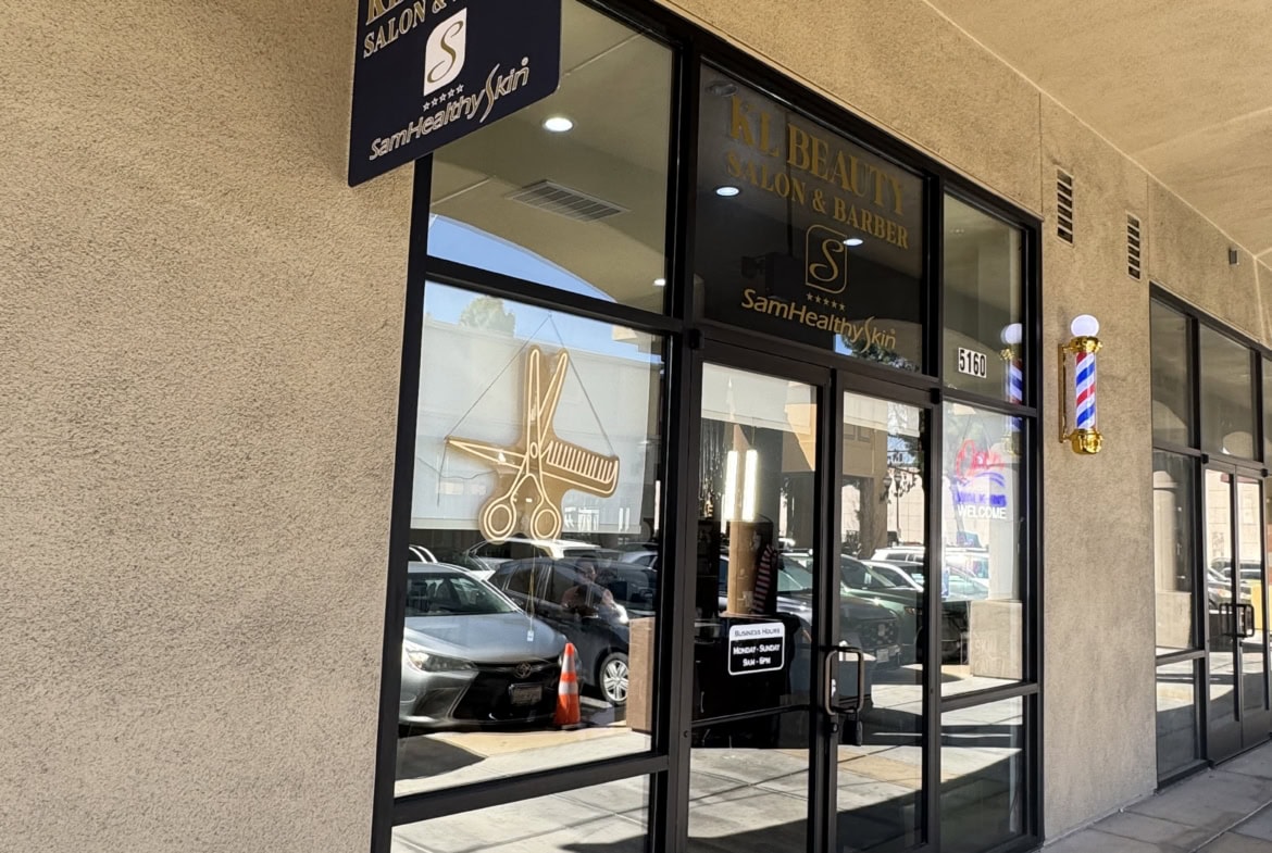 Beauty salon storefront with glass doors and signage.
