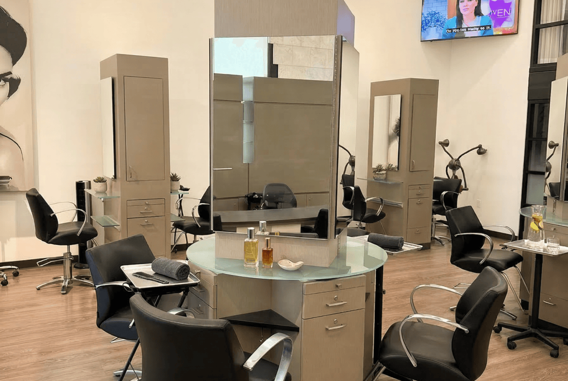 Modern salon station with styling chairs, mirrors, and a TV in a professional hair salon.