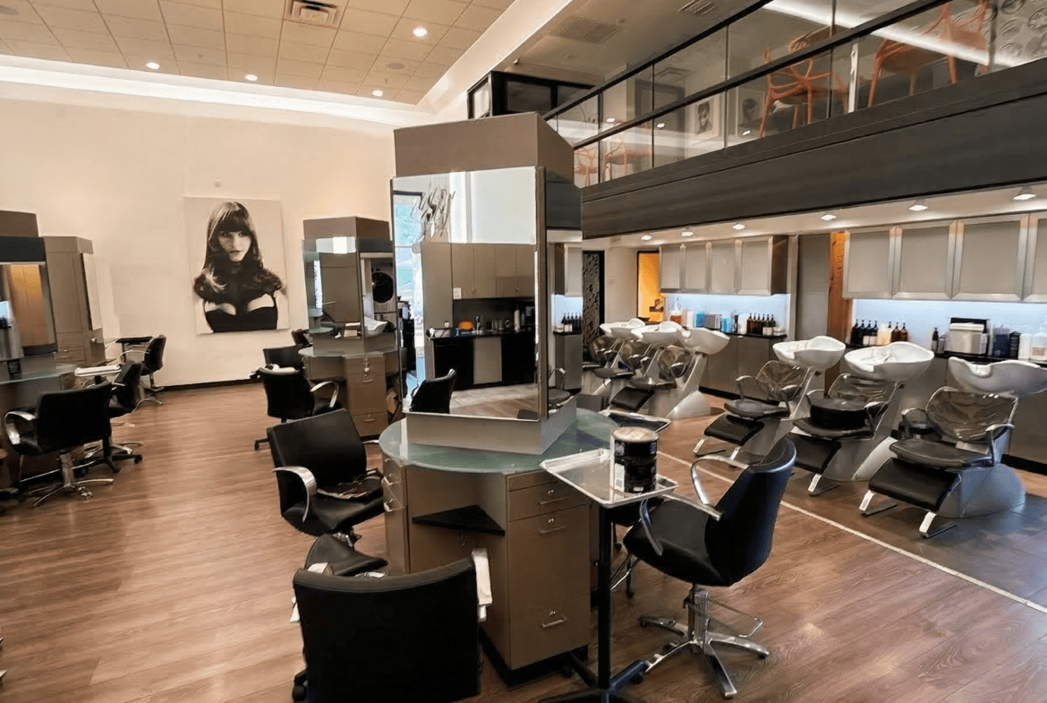 Stylish salon interior with hair stations, wash basins, and modern decor.