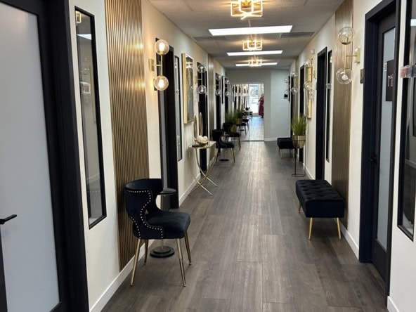 Salon hallway with modern decor, lighting, and seating for salon rental professionals.