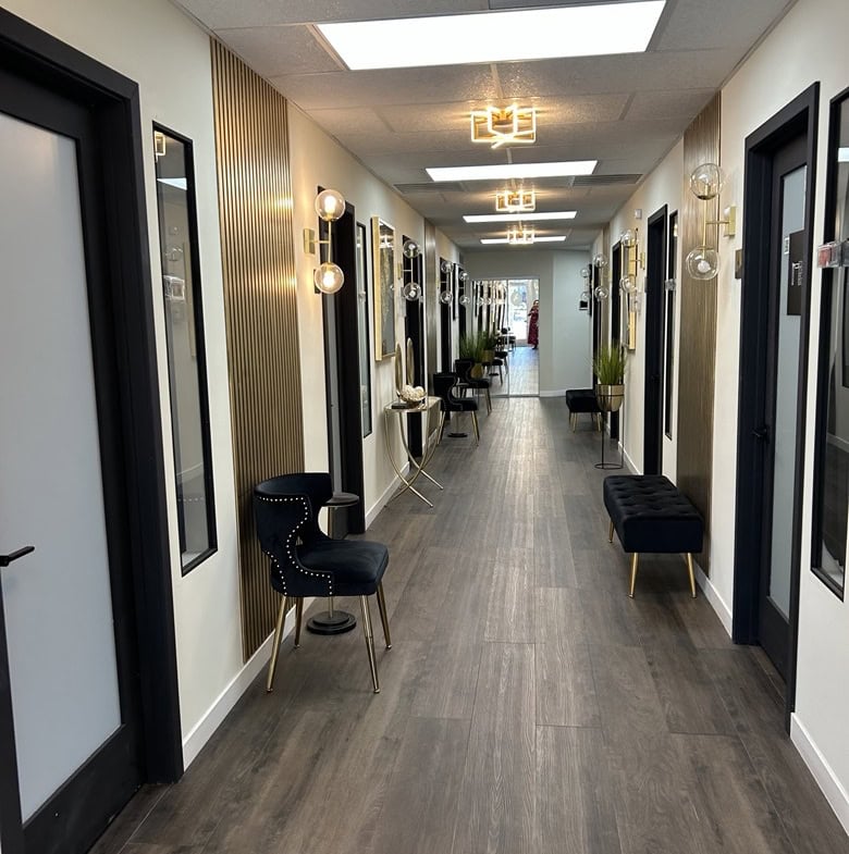 Salon hallway with modern decor, lighting, and seating for salon rental professionals.