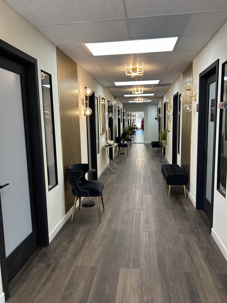 Salon hallway with modern decor, lighting, and seating for salon rental professionals.