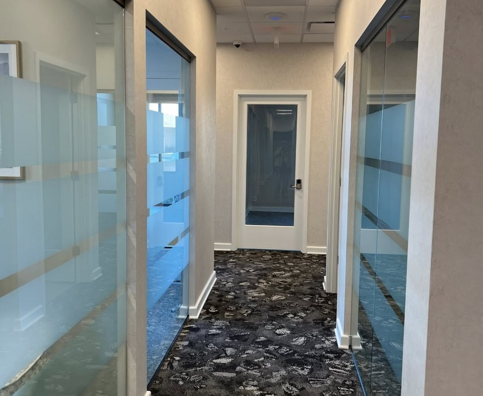 Office hallway with glass-walled rooms at Salon Renter.