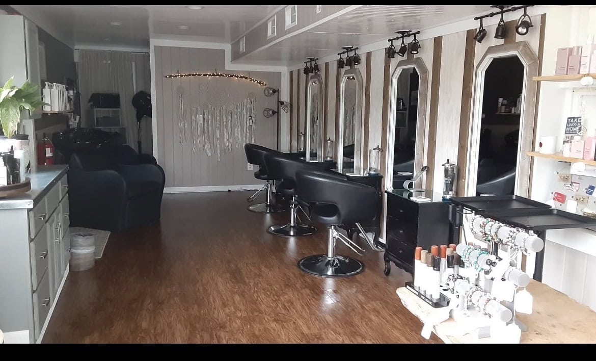 Modern salon interior with styling stations and mirrors for hair services.