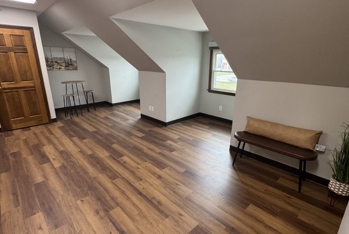 Bright, open salon rental with hardwood floors and large windows for a welcoming atmosphere.