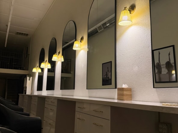 Salon Renter styling station with mirrors and warm lighting for hairdressing.