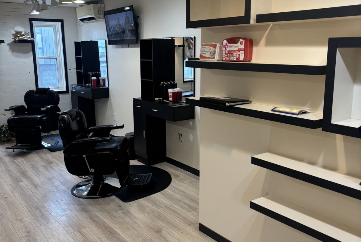 Modern salon interior with styling chairs, mirrors, and shelves for hair styling and beauty services.