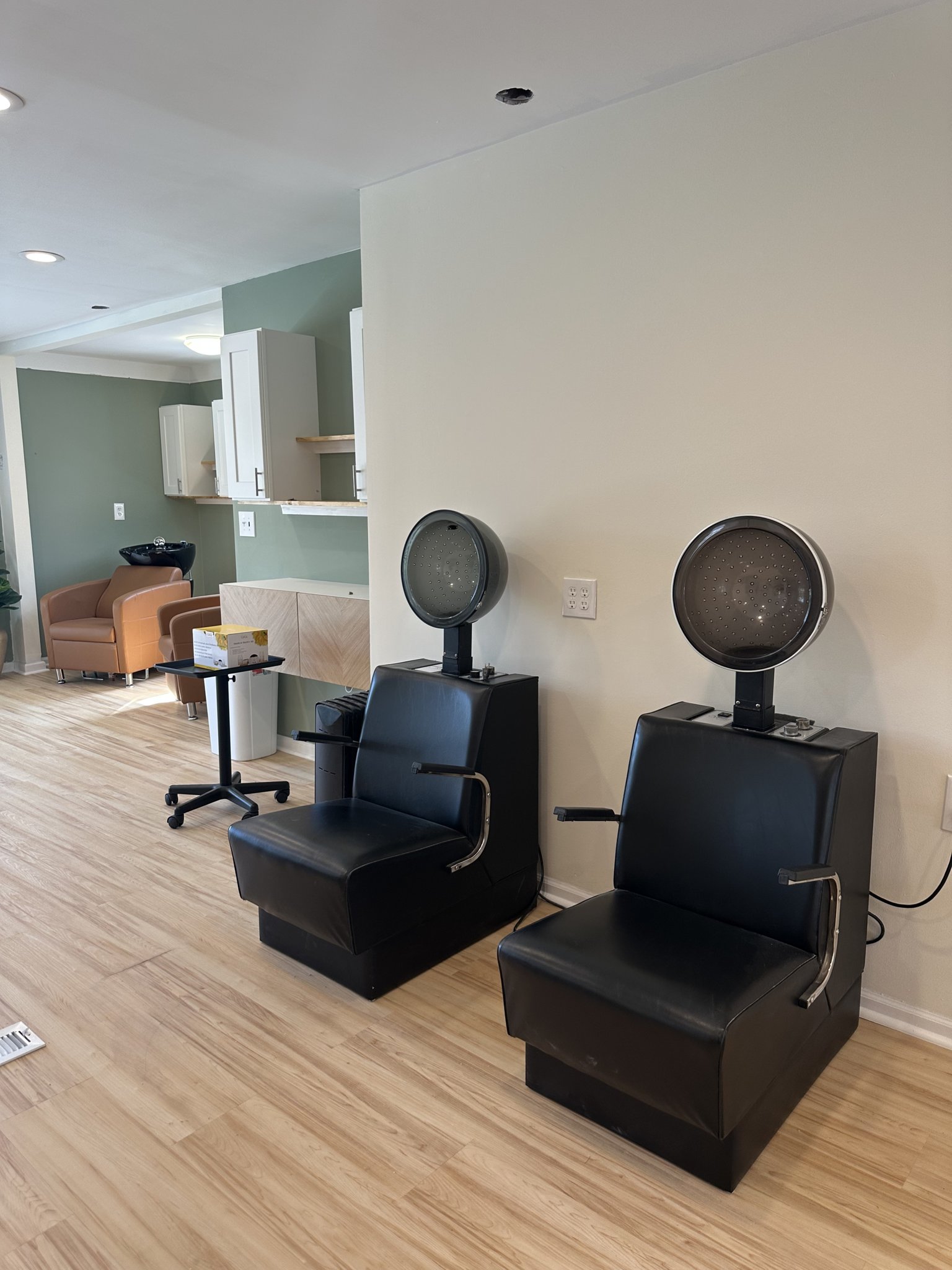 Hair washing stations with chairs and sinks in a modern salon setting.