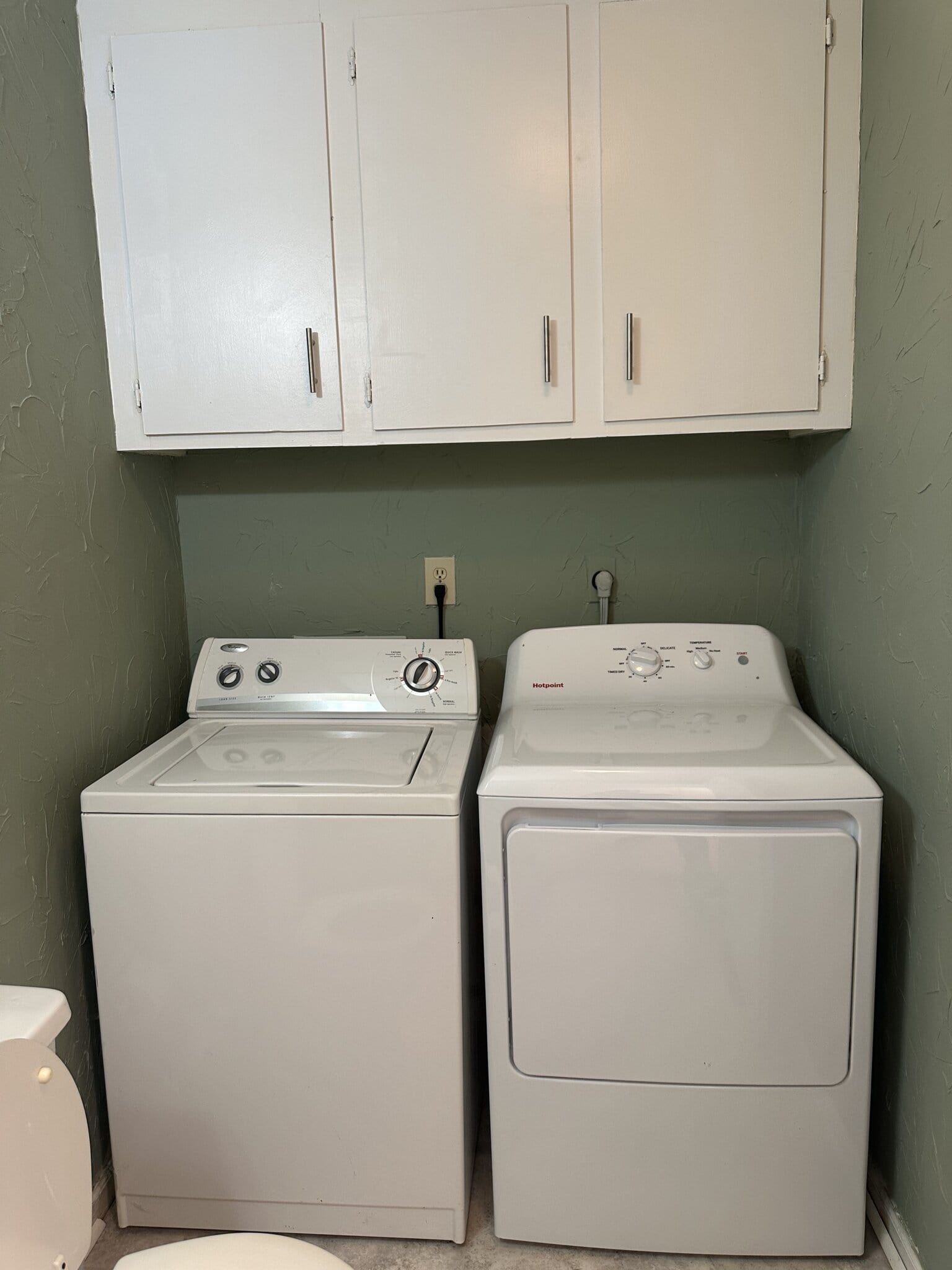 Laundry room with washer and dryer for salon business use.