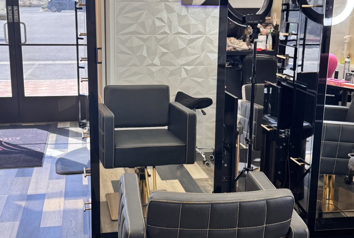 Stylish salon station with a large mirror and comfortable black chair, ideal for professional hairst.