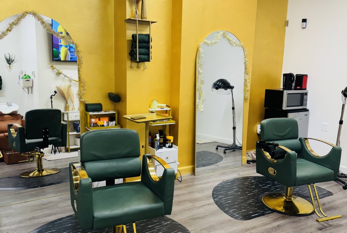 Stylish salon with green chairs, mirrors, and professional hair styling stations.