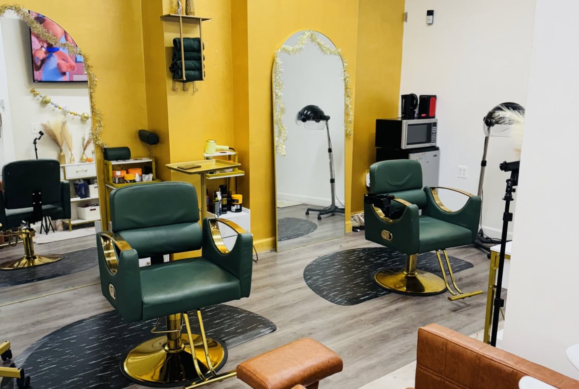 Stylish hair salon interior featuring green styling chairs, mirrors, and professional equipment for.
