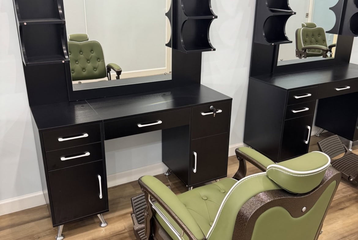 Salon Renter styling station with mirror, shelves, and chair for hairdressing services.
