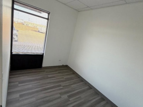 Office space with window and neutral decor for salon rental.