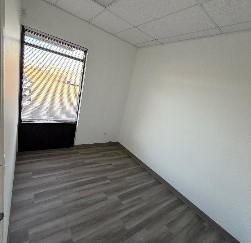 Office space with window and neutral decor for salon rental.