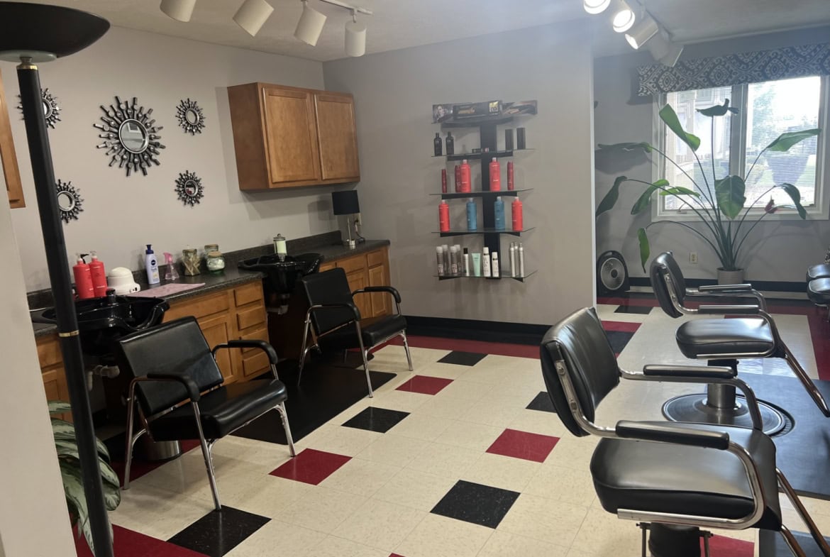 Salon Renter hair salon station with chairs and product shelves for styling and hair care.
