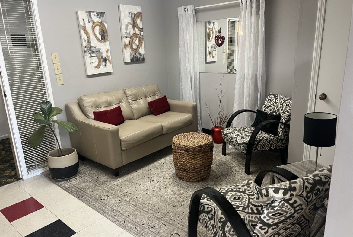 Waiting area in a salon with comfortable seating and stylish decor.