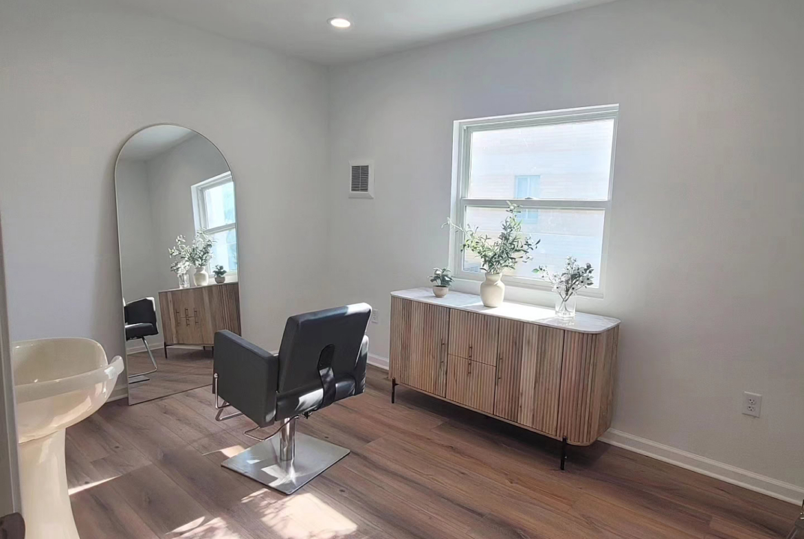 Salon Renter styling station with mirror and natural light, ideal for beauty professionals.