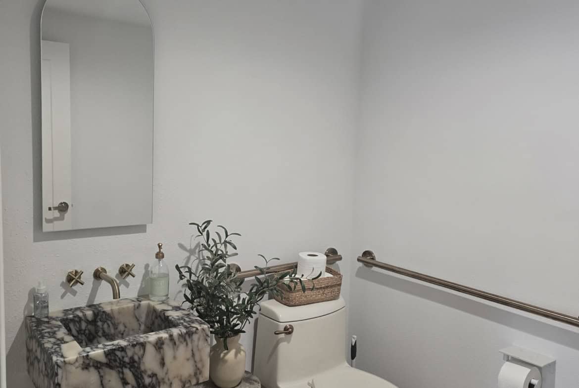 Bathroom with accessible sink, toilet, and grab bar for comfort and convenience.