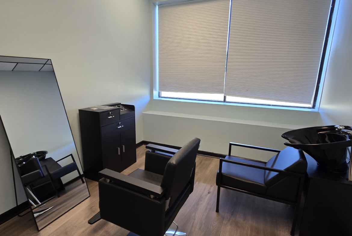 Stylish salon interior featuring a styling chair, mirror, and hair washing station.