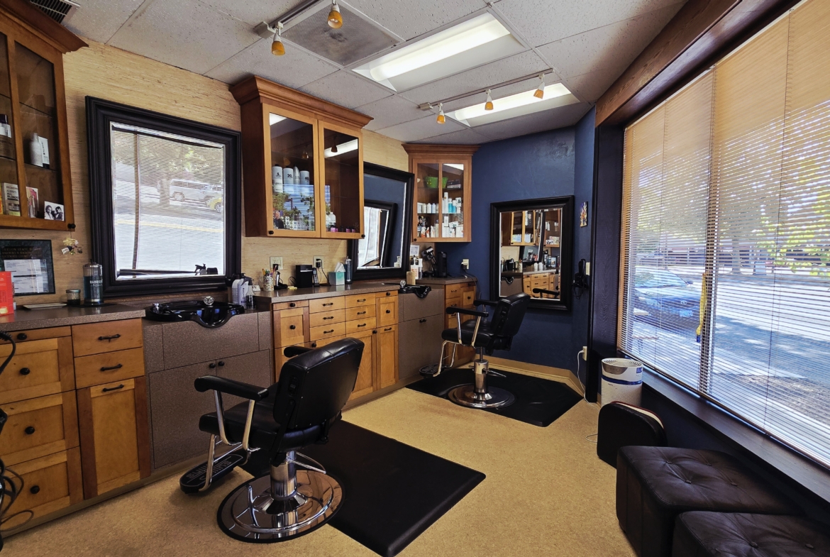 Stylish salon space with workstations, large windows, and professional equipment.